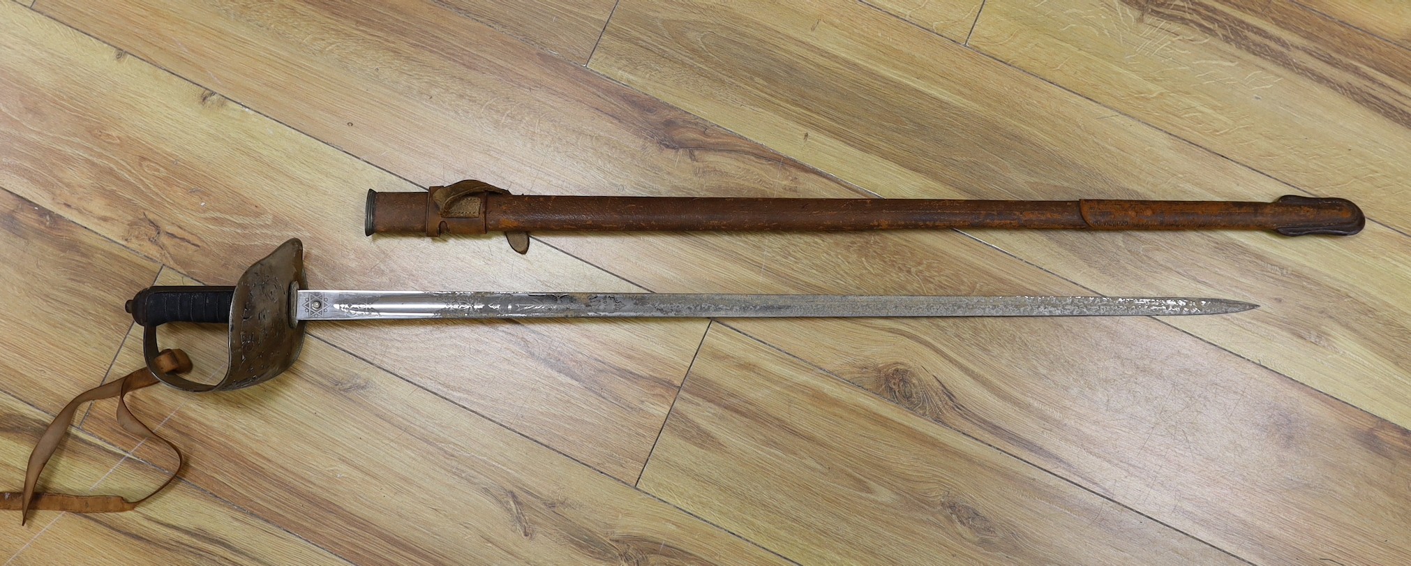 A George V military dress sword in brown leather covered scabbard, 102cm long, and a Middle Eastern dagger with carved and painted handle